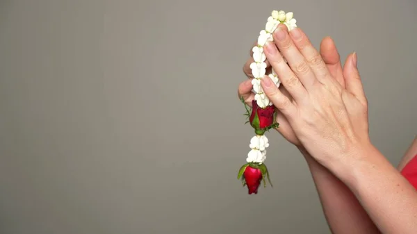 Direction des fleurs entre les mains de jeunes femmes, guirlande de fleurs . — Photo