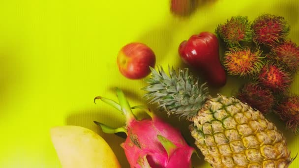 Frutti tropicali su uno sfondo giallo brillante. Concetto di frutta minimo. copia spazio — Video Stock