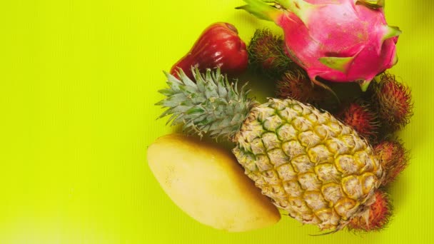 Frutas tropicales sobre un fondo amarillo brillante. Concepto de fruta mínima. espacio de copia — Vídeos de Stock