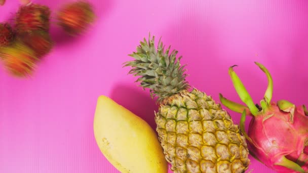 Tropische Früchte auf einem leuchtend rosa Hintergrund. Minimales Fruchtkonzept. — Stockvideo