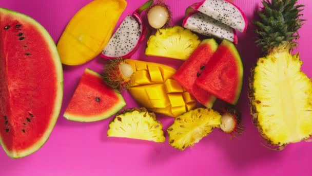 Fruta tropical em um fundo rosa brilhante. fatias Conceito mínimo de fruta . — Vídeo de Stock
