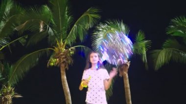 mutlu genç kız büyük havadar, parlayan balon palmiye ağaçları arka planı onun elinde tutan. akşam saat. Turizm ve plaj tatil kavramı