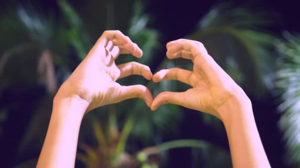 Жінка Показує Форму Серця Пальцями Тлі Пальмових Дерев Ввечері — стокове відео