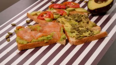 baharat şeritli siyah beyaz arka plan üzerinde avokado tost ekmek üzerinde. Sağlıklı beslenme kavramı.