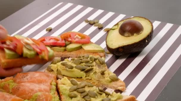 Авокадо на тостному хлібі зі спеціями на смугастому чорно-білому тлі. Концепція здорового харчування . — стокове відео