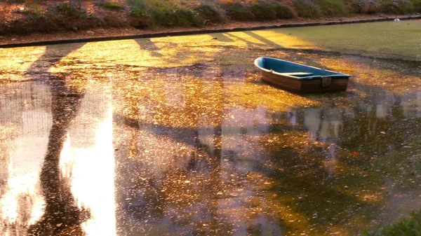 Um velho barco abandonado no meio de um rio sujo — Fotografia de Stock