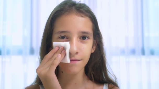 青少年护肤的概念。十几岁的女孩用棉签清洁脸上的皮肤, 用化妆水. — 图库视频影像