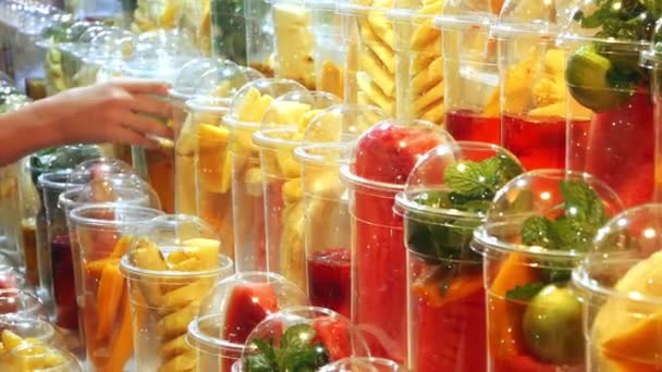 Concept asiatique de street food. Thaïlande. fruits en tasses, tranchés pour faire des smoothies sur le support d'un kiosque extérieur . — Video