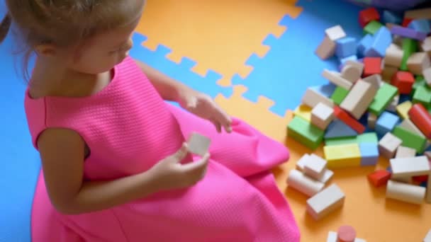 Pequeña chica linda asiática jugando cubos, sentado en un piso de color. El concepto de desarrollo infantil . — Vídeos de Stock