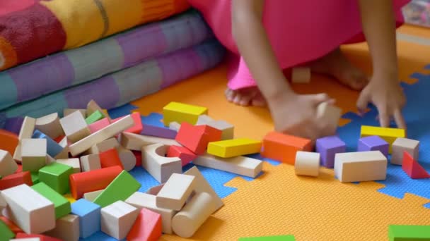 Kis-ázsiai aranyos lány játék kocka, egy színes padlón ül. A gyermek fejlődési koncepció. — Stock videók