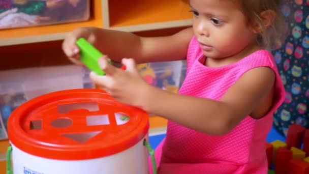 Piccola ragazza asiatica carina gioca giochi educativi con i cubi. studio della forma geometrica degli oggetti . — Video Stock