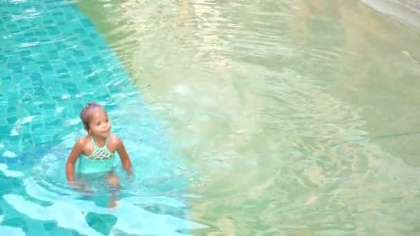 Азиатская милая маленькая девочка играет в бассейне — стоковое видео