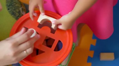 Küçük şirin Asyalı kız küpleriyle Eğitsel Oyunlar oynar. çalışma nesnelerinin geometrik şekil.