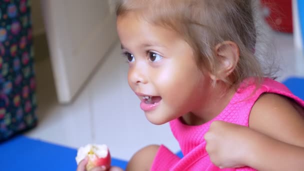 Little cute asian girl eats an apple — Stock Video