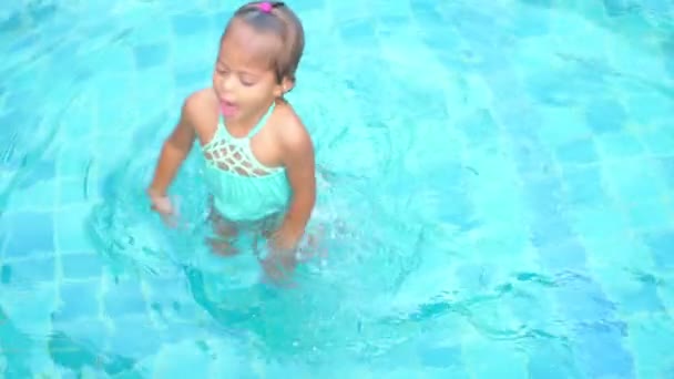 Asiático lindo niña jugando en la piscina — Vídeo de stock