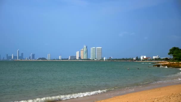 Vista de la ciudad moderna, rascacielos desde la orilla de la playa lejos de la ciudad. mar paisaje urbano . — Vídeos de Stock