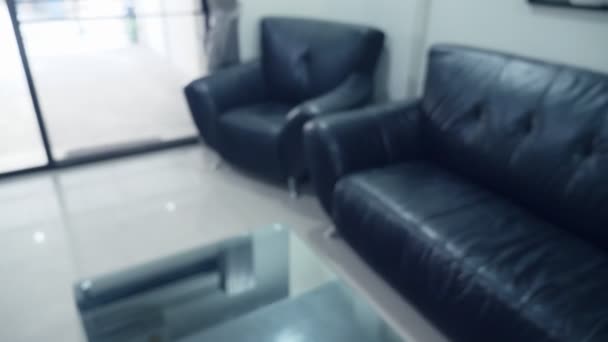 Rozmazané pozadí. interiér moderní obývací pokoj s černým koženým nábytek a skleněné tabulky — Stock video