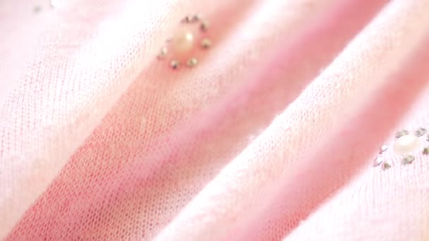 背景从温和的粉红色球衣与水钻。特写。针织面料纹理. — 图库视频影像
