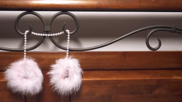 Fur handcuffs and lace mask on the forged headboard. close-up — Stock Video