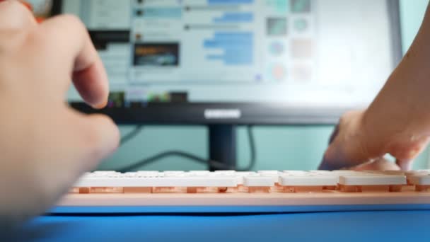 Zbliżenie. Widok pierwszoosobowy. Kobiece ręce pisania na różowe wiadomości klawiatury w sieciach społecznościowych, na tle niewyraźne ekranie komputera — Wideo stockowe