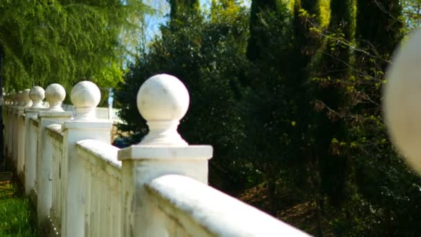 Witte balustrade met versieringen van ballen in een tropisch park — Stockvideo