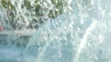 şehir merkezinde çeşmeler etrafında yürüyüş insanlar ile bulanık bir arka plan üzerinde şehir çeşme su jeti.