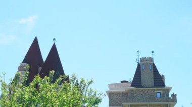 Viktorya tarzında lüks otel, güzel ağaçlar ve çalılar dalmış. berrak mavi gökyüzü bir arka plan üzerinde spiers ile çatılar