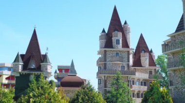 Viktorya tarzında lüks otel, güzel ağaçlar ve çalılar dalmış. berrak mavi gökyüzü bir arka plan üzerinde spiers ile çatılar