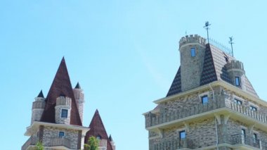 Viktorya tarzında lüks otel, güzel ağaçlar ve çalılar dalmış. berrak mavi gökyüzü bir arka plan üzerinde spiers ile çatılar