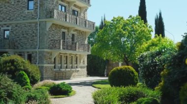 Viktorya tarzında lüks otel, güzel ağaçlar ve çalılar dalmış. berrak mavi gökyüzü bir arka plan üzerinde spiers ile çatılar