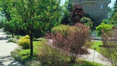 Viktorya tarzında lüks otel, güzel ağaçlar ve çalılar dalmış. berrak mavi gökyüzü bir arka plan üzerinde spiers ile çatılar