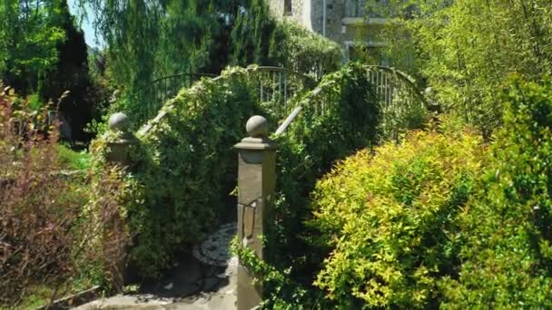 Hôtel luxueux dans le style victorien, immergé dans de beaux arbres et buissons. toits avec des araignées sur un fond de ciel bleu clair — Video