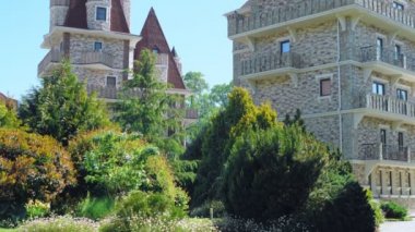 Viktorya tarzında lüks otel, güzel ağaçlar ve çalılar dalmış. berrak mavi gökyüzü bir arka plan üzerinde spiers ile çatılar