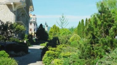 Viktorya tarzında lüks otel, güzel ağaçlar ve çalılar dalmış. berrak mavi gökyüzü bir arka plan üzerinde spiers ile çatılar