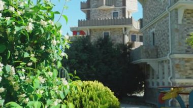 Viktorya tarzında lüks otel, güzel ağaçlar ve çalılar dalmış. berrak mavi gökyüzü bir arka plan üzerinde spiers ile çatılar