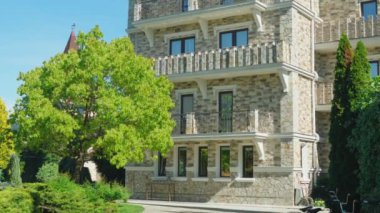 Viktorya tarzında lüks otel, güzel ağaçlar ve çalılar dalmış. berrak mavi gökyüzü bir arka plan üzerinde spiers ile çatılar