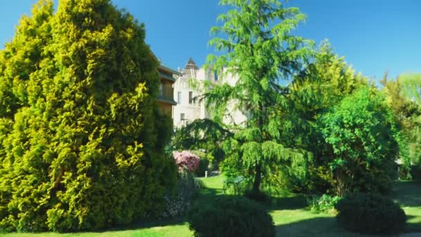 Hotel di lusso in stile vittoriano, immerso in splendidi alberi e arbusti. Tetti con guglie sullo sfondo di una cresta e un cielo azzurro chiaro. dall'alto — Video Stock