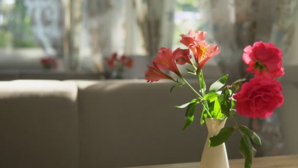 Gros plan. Mignon bouquet de roses rouges et freesia dans un vase sur une table lors d'une journée d'été ensoleillée dans un café — Video