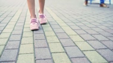 Close. şık pembe spor ayakkabı kadın bacakları. kaldırımile sokakta yürüyen kız. Doğal güneşli gün ışığı