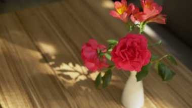 gül ve freesia güzel bir buket ve masanın üzerinde gölge, perde ile güneş ışığı ile aydınlatılmış