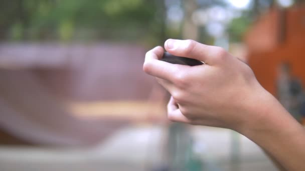 adolescent garçon seul à l'aide d'un téléphone portable sur le fond d'un skate park. tandis que d'autres enfants se détendent activement. Dépendance au smartphone 