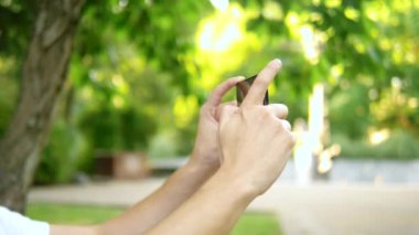 Close. Bir adam blogcu bir park bankında otururken bir akıllı telefon kullanır. Birisiyle görüntülü görüşmesi var.