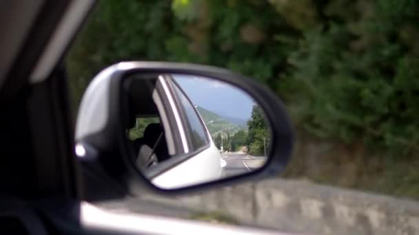 Hermosas montañas se pueden ver en el espejo retrovisor mientras se conduce — Vídeo de stock