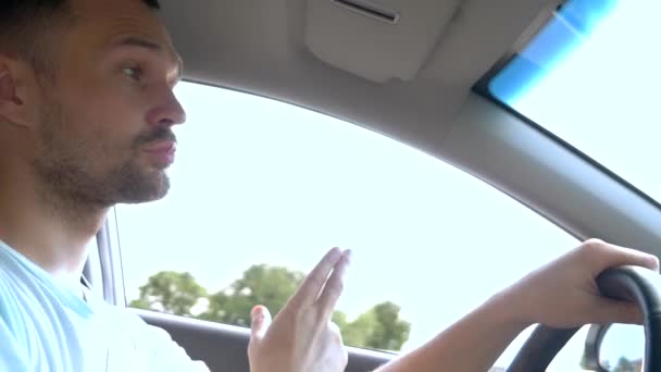 Close-up. bonito homem dirigindo um carro, dançando e ouvindo música . — Vídeo de Stock