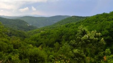 mavi gökyüzü ve beyaz bulutlar akar sis ile görünen zirveleri görünür siluetleri ile dağ sırası