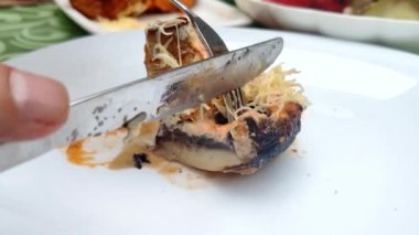 birisi çatal ve bıçakla pişmiş mantar bir parça keser