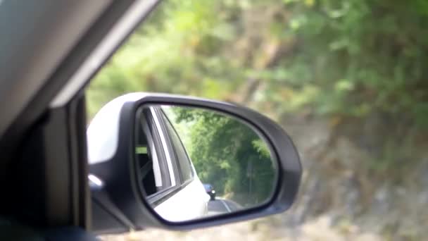 Araba kovalamaca kavramı. araç penceresinden görüntüleyin. dikiz aynasında görünür kırmızı araba takipçisi. — Stok video