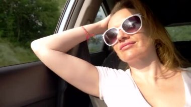 güneş gözlüğü mutlu genç kadın arabanın açık pencereye bakar, ve onun uzun saçları rüzgar tarafından heyecanlı. otomatik seyahat ve macera konsepti