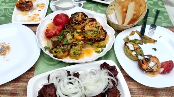 Close-up. Kebabs cozidos com cebola com legumes e cogumelos grelhados. na mesa do restaurante — Vídeo de Stock