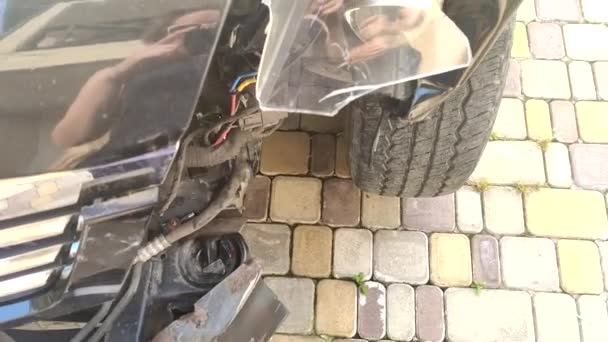 Close-up, draden onder de bumper van een gebroken auto na een ongeval. — Stockvideo